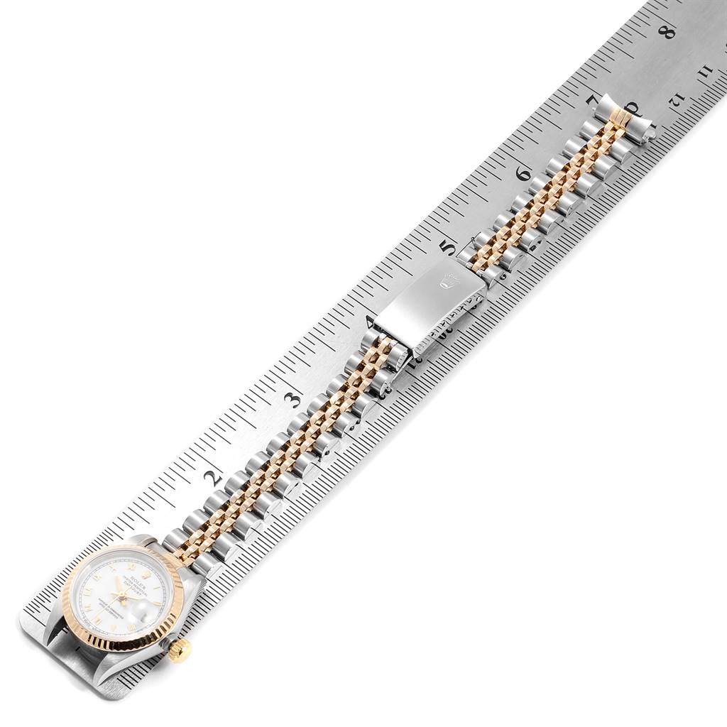 The image shows a Rolex Datejust 69173 Women's Stainless Steel White Dial 69173 Women's Stainless Steel White Dial watch laid flat on a ruler, displaying the watch face, bezel, and bracelet.