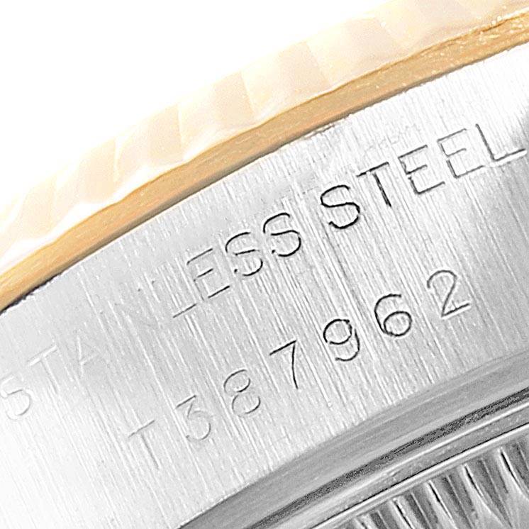 This is a close-up view of the stainless steel case and bezel of a Rolex Datejust 69173 Women's Stainless Steel White Dial 69173 Women's Stainless Steel White Dial watch with visible engravings.