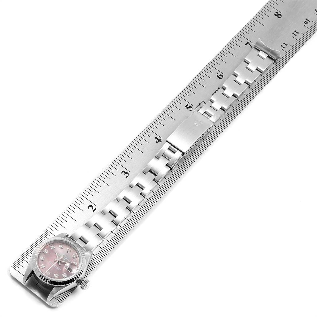The image shows the Rolex Datejust 79174 Women's Stainless Steel Mother of Pearl Dial 79174 Women's Stainless Steel Mother of Pearl Dial watch and its bracelet next to a ruler, highlighting its length and design.