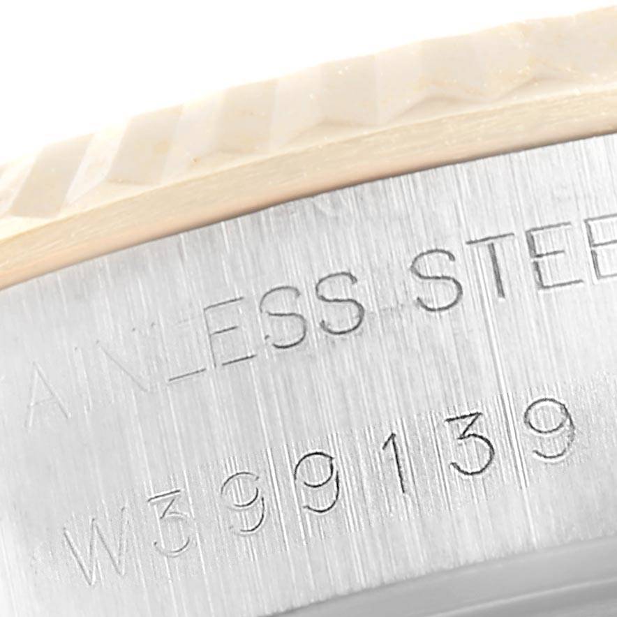 This image shows a close-up of the side of a stainless steel Rolex Datejust 69173 Women's Stainless Steel Champagne Dial 69173 Women's Stainless Steel Champagne Dial model, including its fluted bezel and engraved serial number.