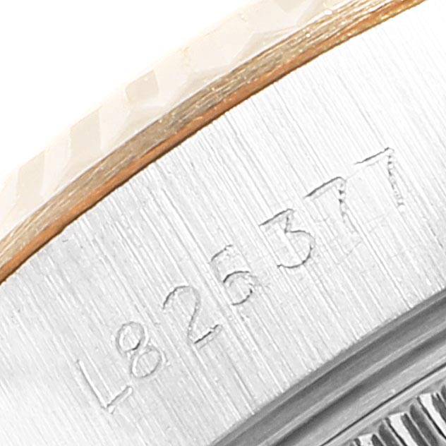 This close-up image shows the engraved serial number and a portion of the fluted bezel on a Rolex Datejust 69173 Women's Stainless Steel Silver Dial 69173 Women's Stainless Steel Silver Dial watch.