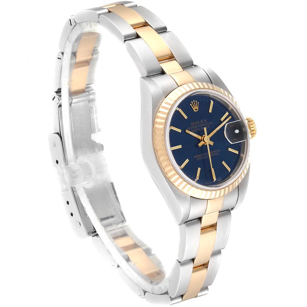 The Rolex Datejust 79173 Women
s Steel and Gold (two tone) Blue Dial 79173 Women
s Steel and Gold (two tone) Blue Dial watch is shown at a three-quarter angle, highlighting its blue dial, fluted bezel, and two-tone bracelet.