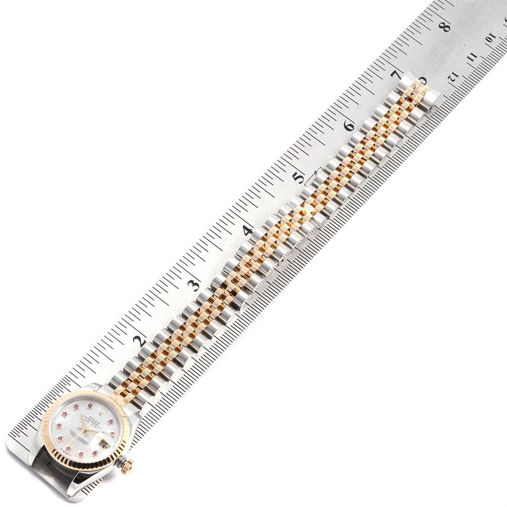 The Rolex Datejust 179173 Women's Steel and Gold (two tone) Mother of Pearl Dial 179173 Women's Steel and Gold (two tone) Mother of Pearl Dial watch is shown from above, displaying the face and the full length of the bracelet alongside a ruler.