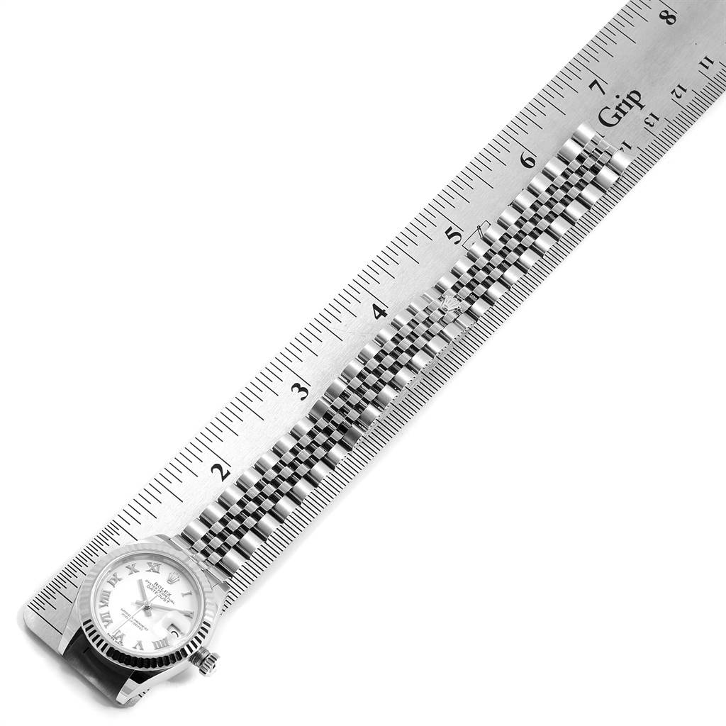 The image shows the Rolex Datejust 279174 Women's Stainless Steel White Dial 279174 Women's Stainless Steel White Dial watch placed on a ruler, displaying the watch face and metal bracelet from an overhead angle.