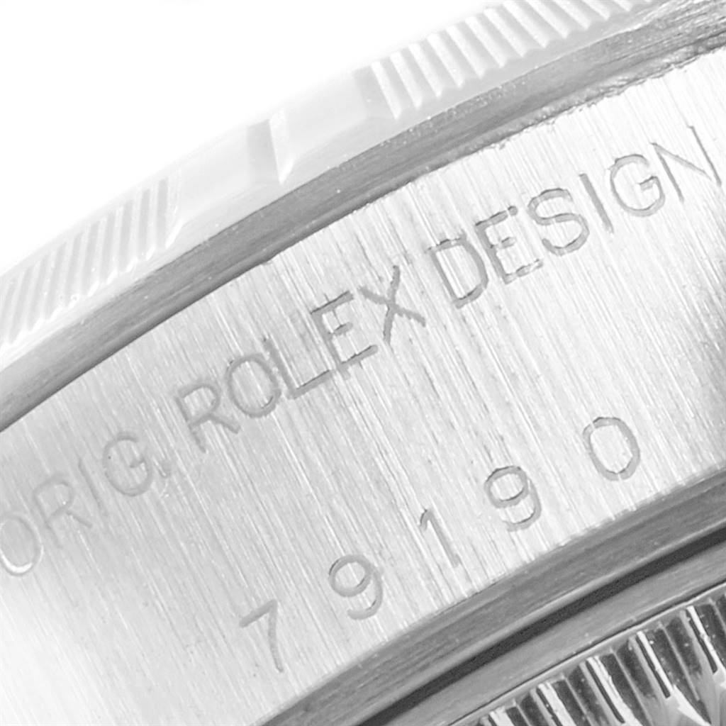 Close-up of the Rolex Datejust 79190 Women's Stainless Steel Black Dial 79190 Women's Stainless Steel Black Dial watch case side, showing the engraving "Rolex Design" and part of the bezel.