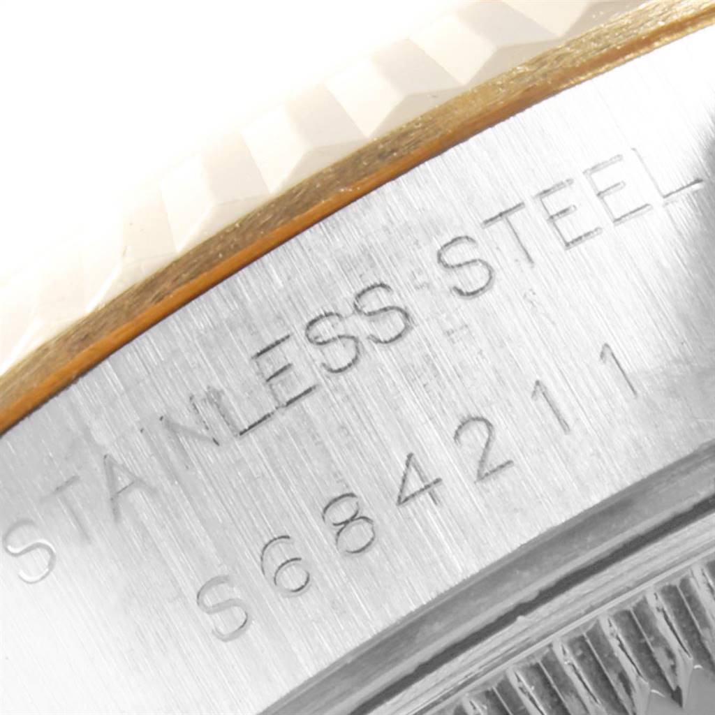 This close-up image shows the side of the case and the bezel of a Rolex Datejust 69173 Women's Stainless Steel White Dial 69173 Women's Stainless Steel White Dial watch, highlighting its "STAINLESS STEEL" engraving.