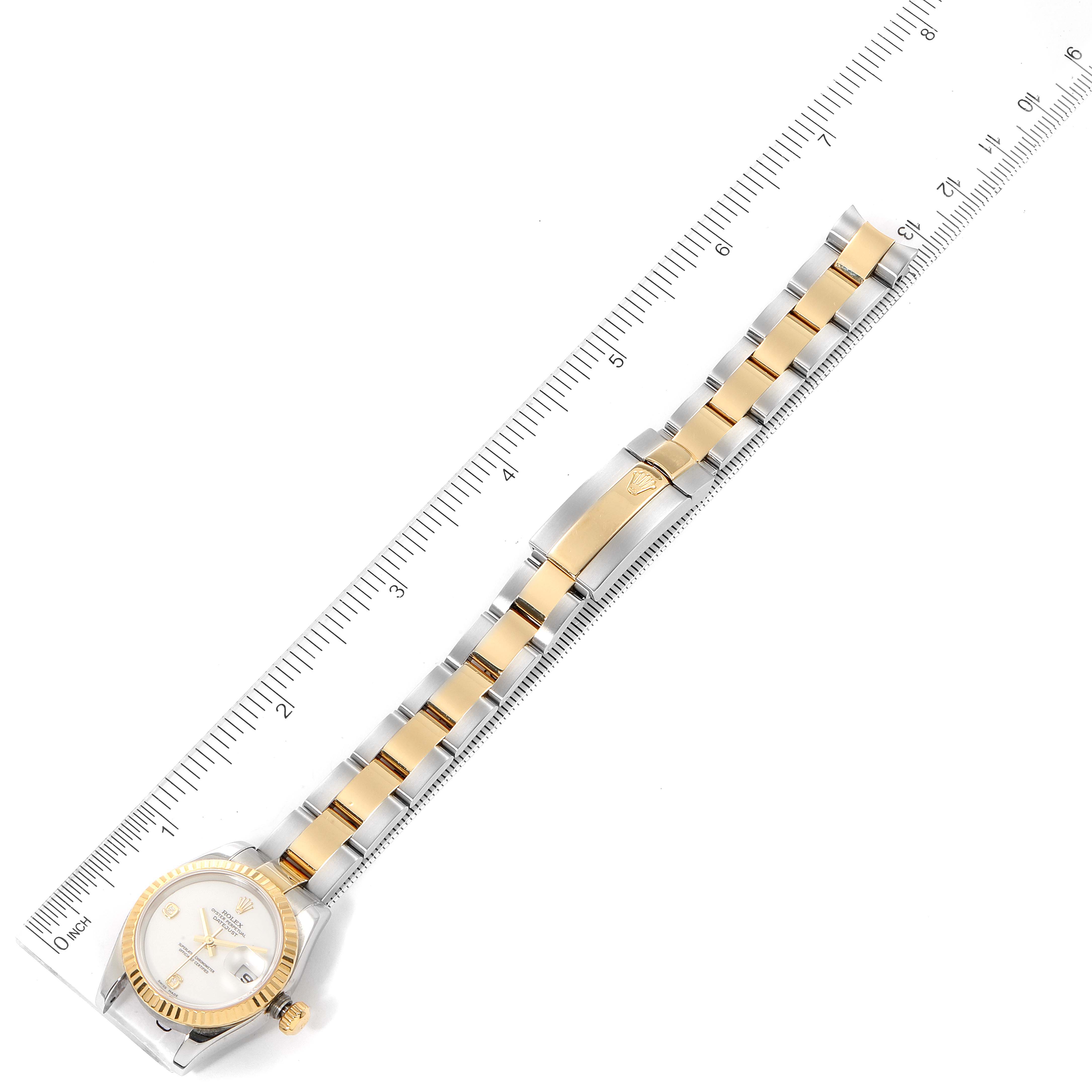 The image shows a full top-down view of a Rolex Datejust 179173 Women's Steel and Gold (two tone) White Dial 179173 Women's Steel and Gold (two tone) White Dial watch alongside a measuring ruler.