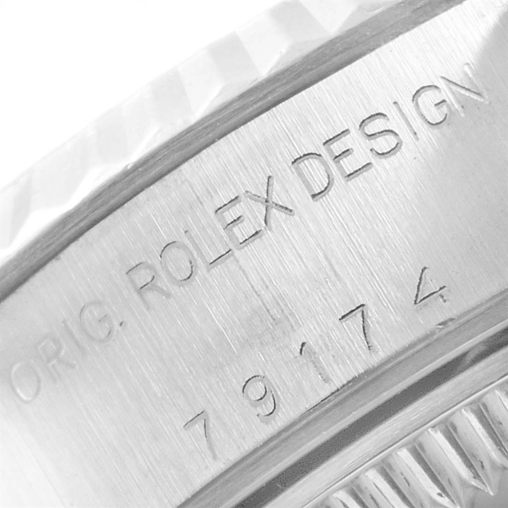 The image shows a close-up of the serial number and the engraved "ROLEX DESIGN" text on the case of a Rolex Datejust 79174 Women
s Stainless Steel Silver Dial 79174 Women
s Stainless Steel Silver Dial watch.