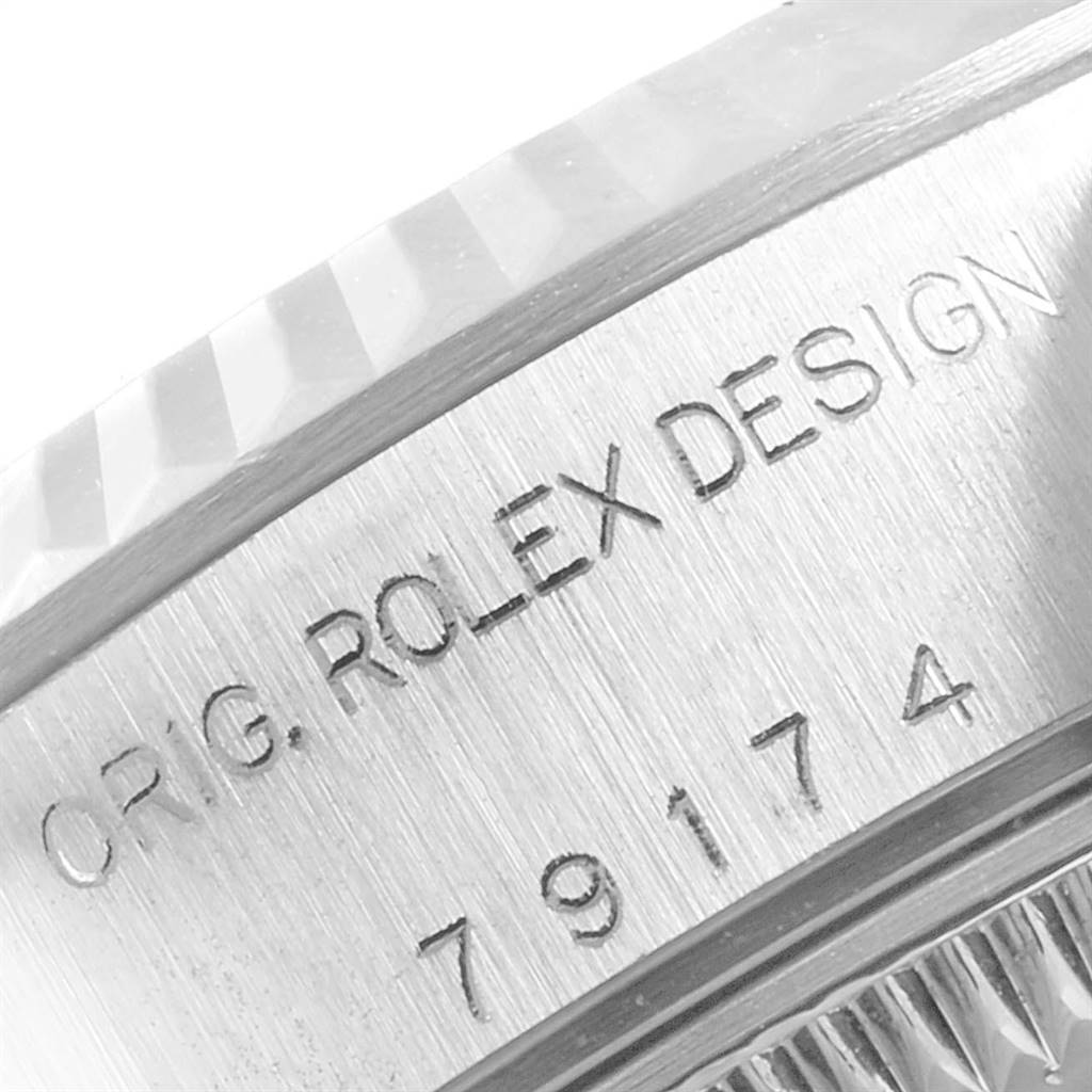 The image shows a close-up of the casing of a Rolex Datejust 79174 Women's Stainless Steel Pink Dial 79174 Women's Stainless Steel Pink Dial watch, featuring the model number and "ORIG. ROLEX DESIGN" engraving.