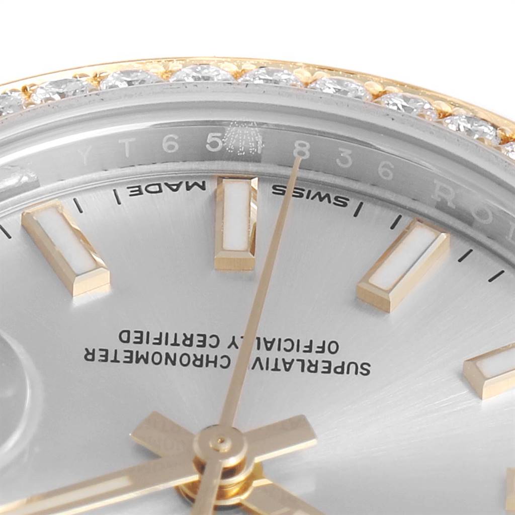 The close-up image of the Rolex Datejust 279383 Women's Steel and Gold (two tone) Silver Dial 279383 Women's Steel and Gold (two tone) Silver Dial watch shows part of the dial, bezel, and indices at an angle.