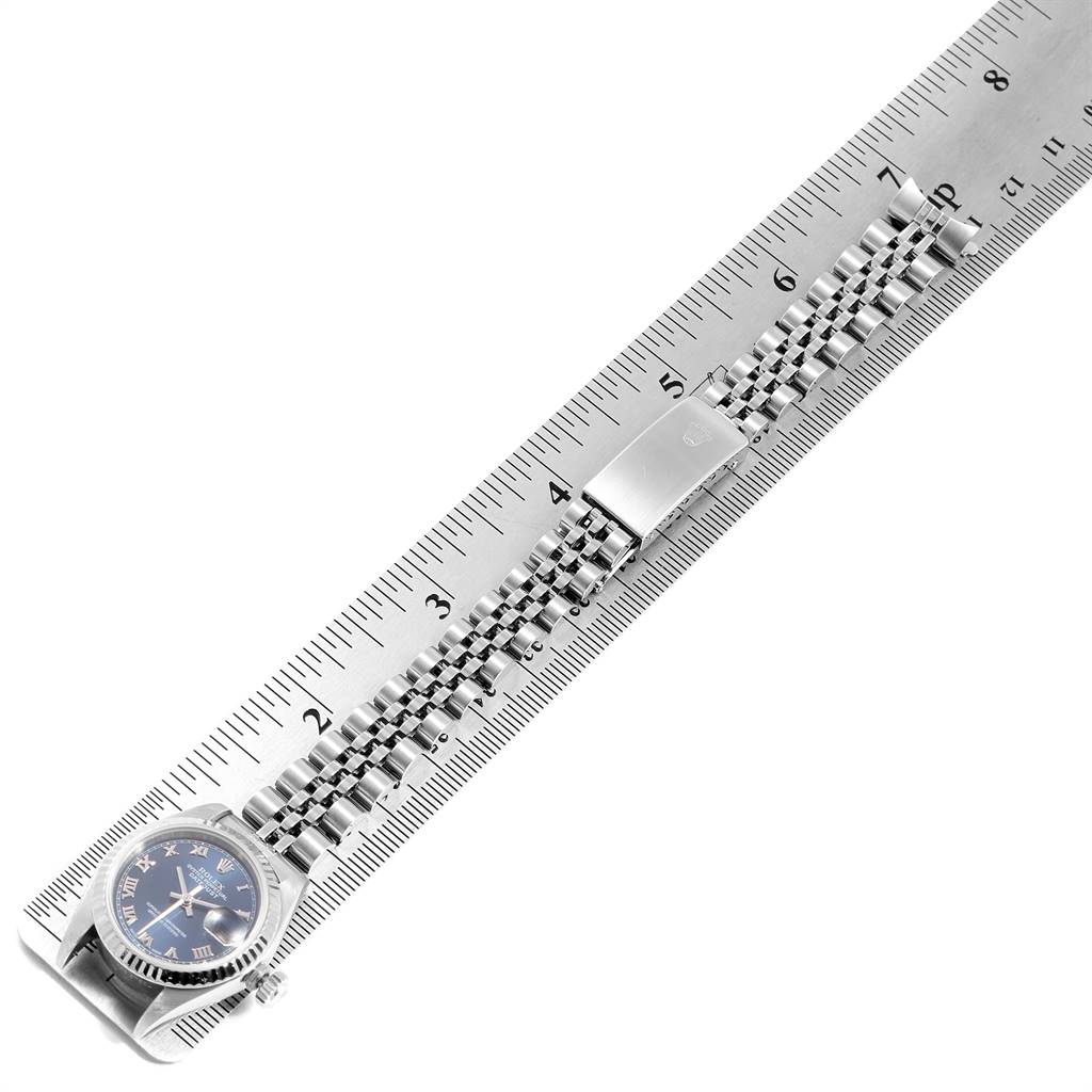 The image shows a Rolex Datejust 79174 Women's Stainless Steel Blue Dial 79174 Women's Stainless Steel Blue Dial with a blue dial and a jubilee bracelet, laid flat next to a ruler for measurement.