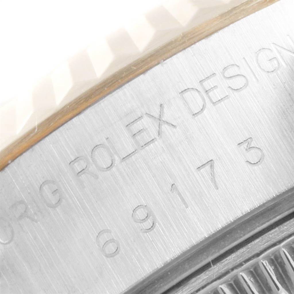 This image shows a close-up of the side of a Rolex Datejust 69173 Women
s Stainless Steel Champagne Dial 69173 Women
s Stainless Steel Champagne Dial watch, featuring the engraving "ROLEX DESIGN" and part of the serial number.