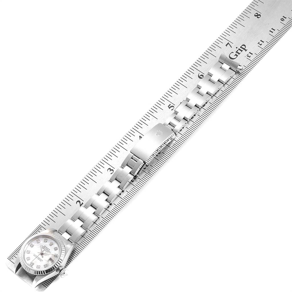 The image shows a Rolex Datejust 79174 Women
s Stainless Steel Mother of Pearl Dial 79174 Women
s Stainless Steel Mother of Pearl Dial watch, focusing on the face and bracelet against a ruler for measurement.