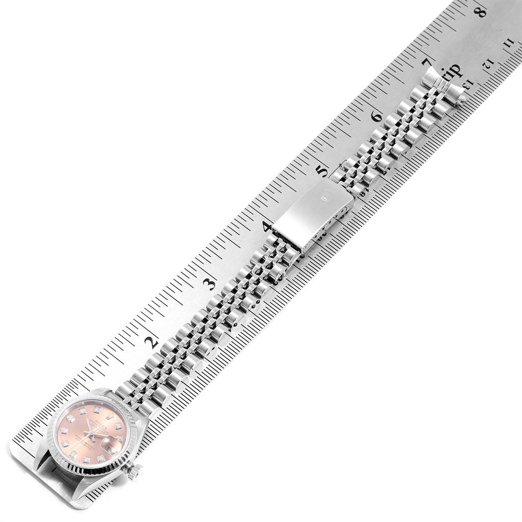 The image shows a Rolex Datejust 79174 Women's Stainless Steel Pink Dial 79174 Women's Stainless Steel Pink Dial watch laid flat, with its bracelet and clasp extended along a ruler for measurement.