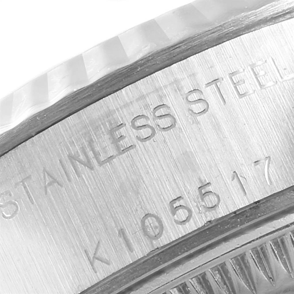 The image shows a close-up of the side of the Rolex Datejust 79174 Women's Stainless Steel Pink Dial 79174 Women's Stainless Steel Pink Dial watch case, highlighting the "STAINLESS STEEL" engraving and part of the serial number.