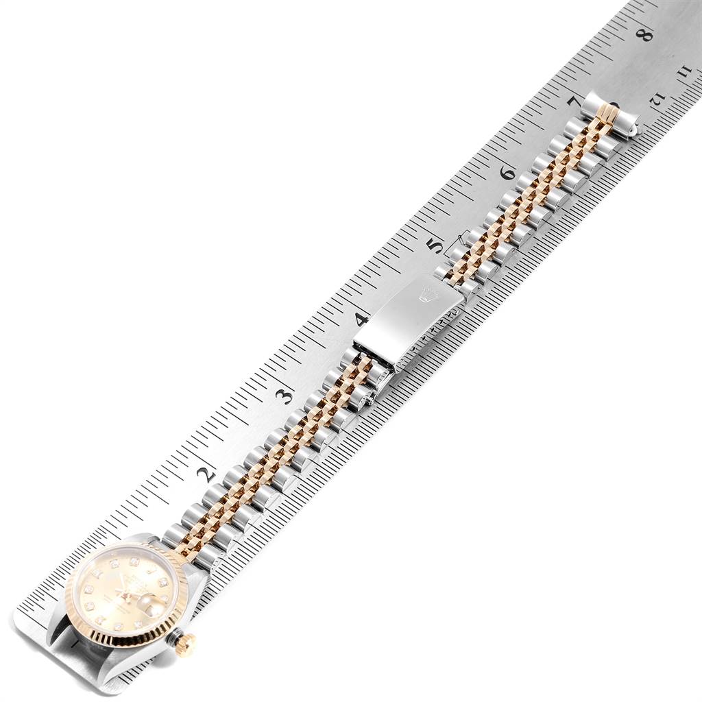 This image shows the Rolex Datejust 69173 Women's Stainless Steel Champagne Dial 69173 Women's Stainless Steel Champagne Dial watch placed parallel to a measuring ruler, highlighting its bracelet and dial from a top-down angle.