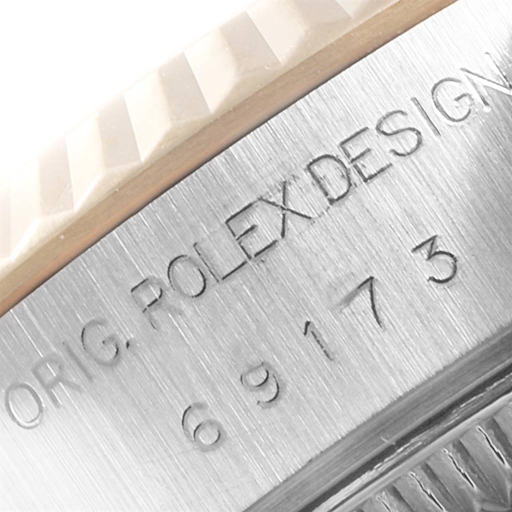 This close-up shot of the Rolex Datejust 69173 Women's Stainless Steel Champagne Dial 69173 Women's Stainless Steel Champagne Dial model shows the engraved "ROLEX DESIGN" text and the fluted bezel.