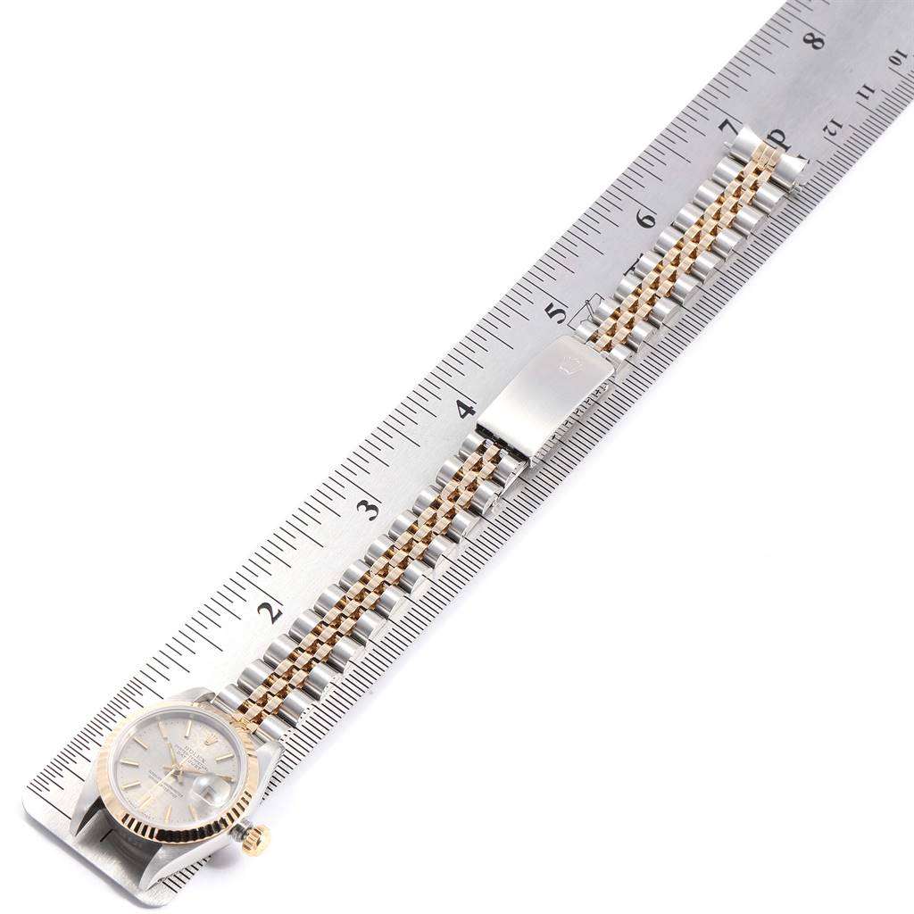 The Rolex Datejust 69173 Women
s Stainless Steel Silver Dial 69173 Women
s Stainless Steel Silver Dial watch is shown flat, with the face, bracelet, and clasp aligned next to a ruler for scale.