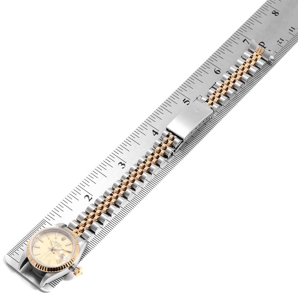 The image shows a Rolex Datejust 69173 Women's Stainless Steel Champagne Dial 69173 Women's Stainless Steel Champagne Dial watch laid flat next to a ruler, displaying its face, band, and clasp.