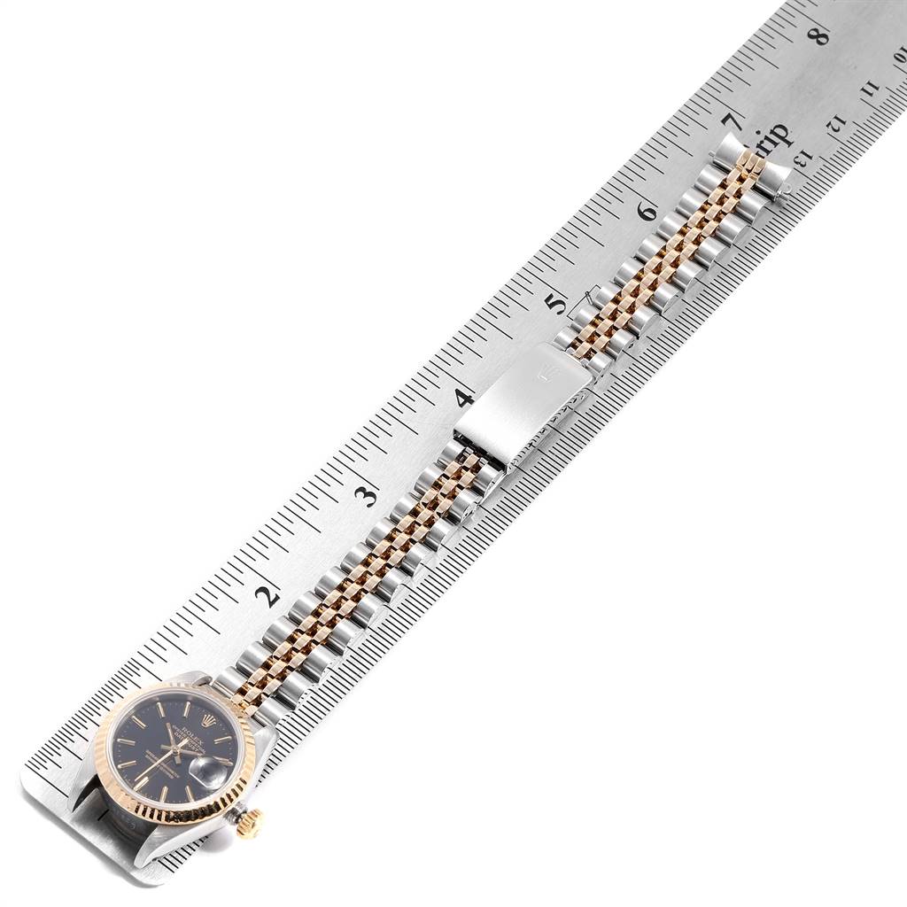 The image shows a Rolex Datejust 69173 Women
s Stainless Steel Black Dial 69173 Women
s Stainless Steel Black Dial watch laid flat measuring its length on a ruler, showcasing the face and band.