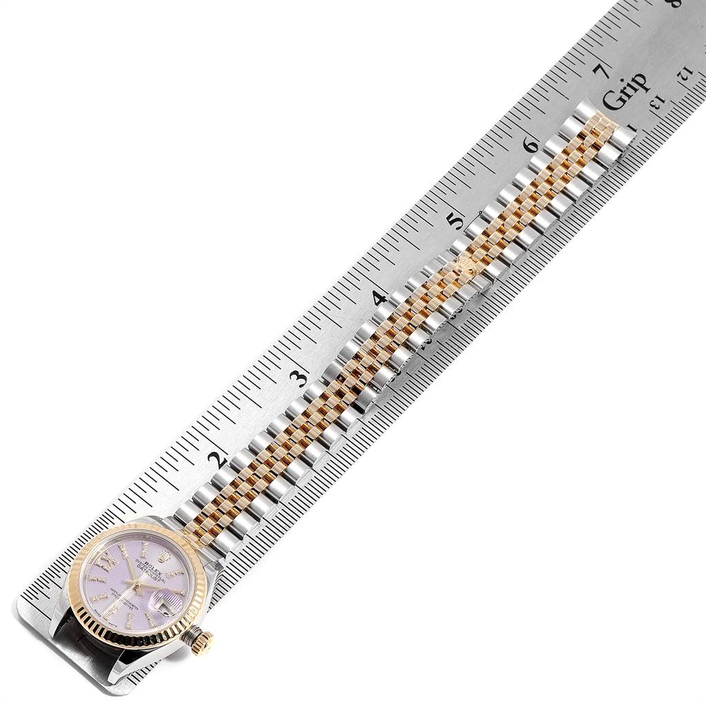 The Rolex Datejust 279173 Women's Steel and Gold (two tone) Purple Dial 279173 Women's Steel and Gold (two tone) Purple Dial watch is shown from an overhead angle, focusing on the face and bracelet laid next to a ruler.
