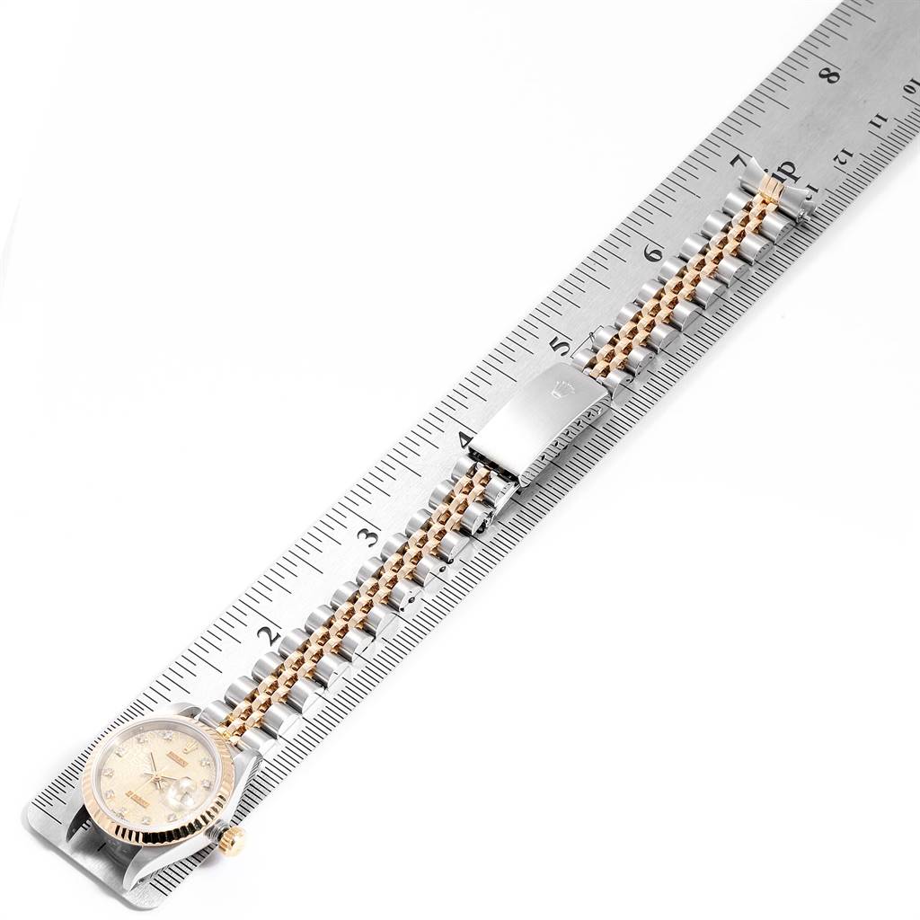 This image shows a Rolex Datejust 69173 Women's Stainless Steel Beige Dial 69173 Women's Stainless Steel Beige Dial watch laid flat on a ruler, highlighting its face, bezel, and bracelet.