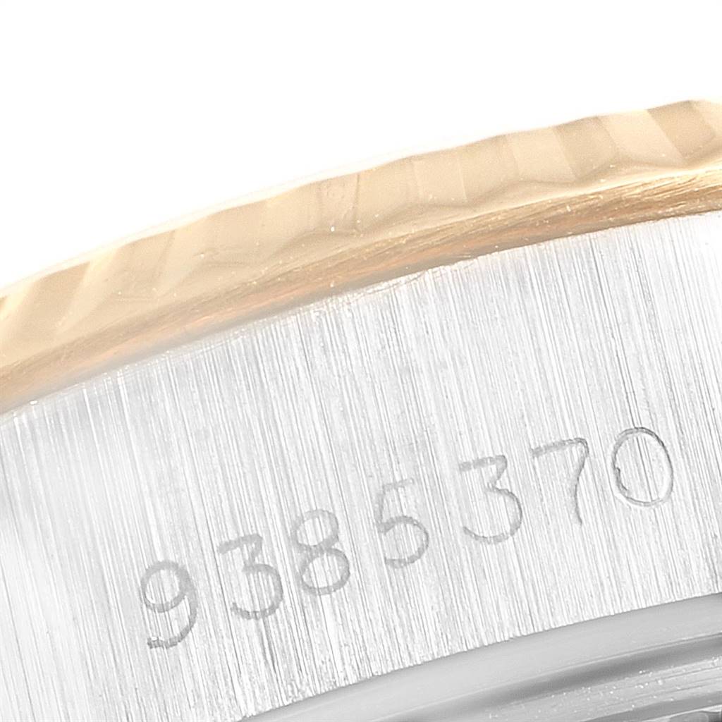 This image shows the serial number on the side of the case of a Rolex Datejust 69173 Women's Stainless Steel Red Dial 69173 Women's Stainless Steel Red Dial model, along with part of the fluted bezel.