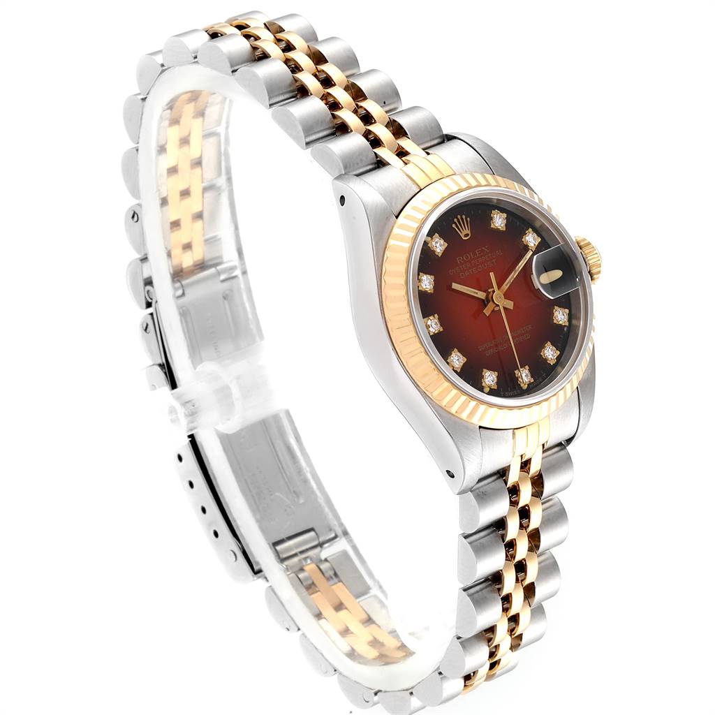 This image shows a Rolex Datejust 69173 Women's Stainless Steel Red Dial 69173 Women's Stainless Steel Red Dial watch from a three-quarter angle, highlighting its dial, fluted bezel, and two-tone bracelet.