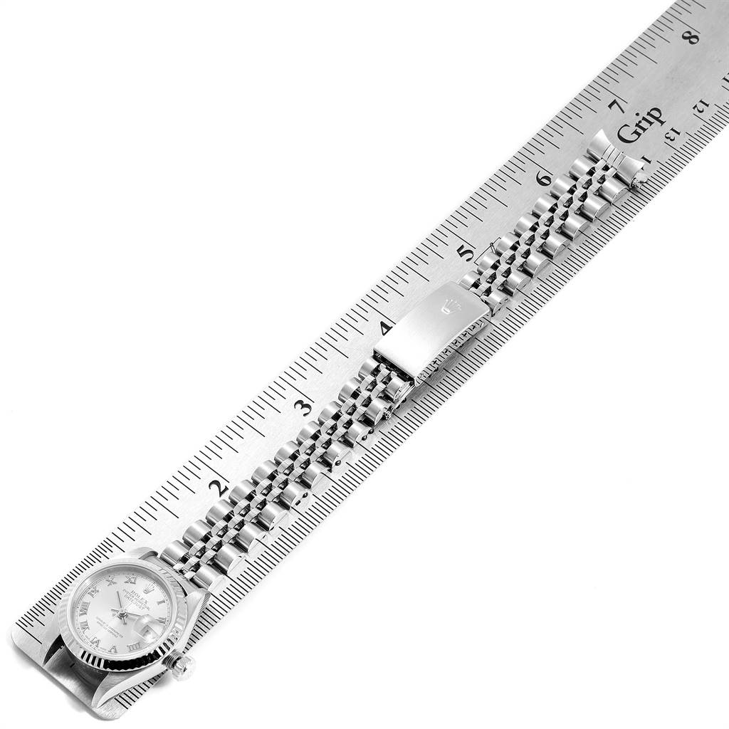 The image shows a Rolex Datejust 79174 Women
s Stainless Steel Silver Dial 79174 Women
s Stainless Steel Silver Dial watch laid flat beside a ruler, displaying its bracelet and the watch face.