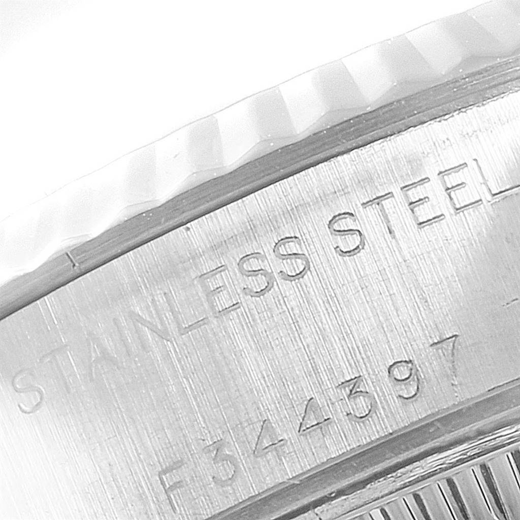 The image shows a close-up of the case side of the Rolex Datejust 79174 Women
s Stainless Steel Black Dial 79174 Women
s Stainless Steel Black Dial watch, highlighting the fluted bezel and engraving.