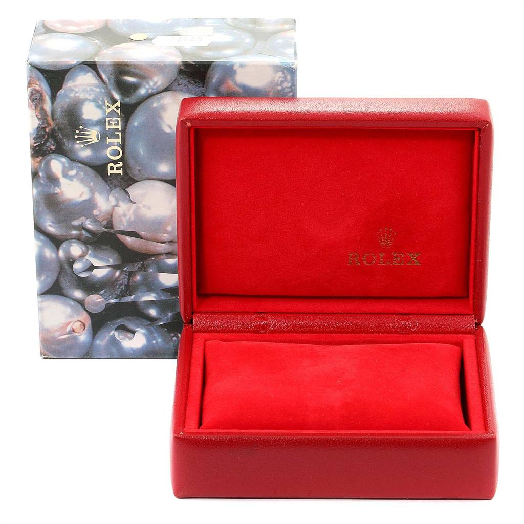 The image shows an open red Rolex watch box for the Datejust model, with the outer packaging in the background.
