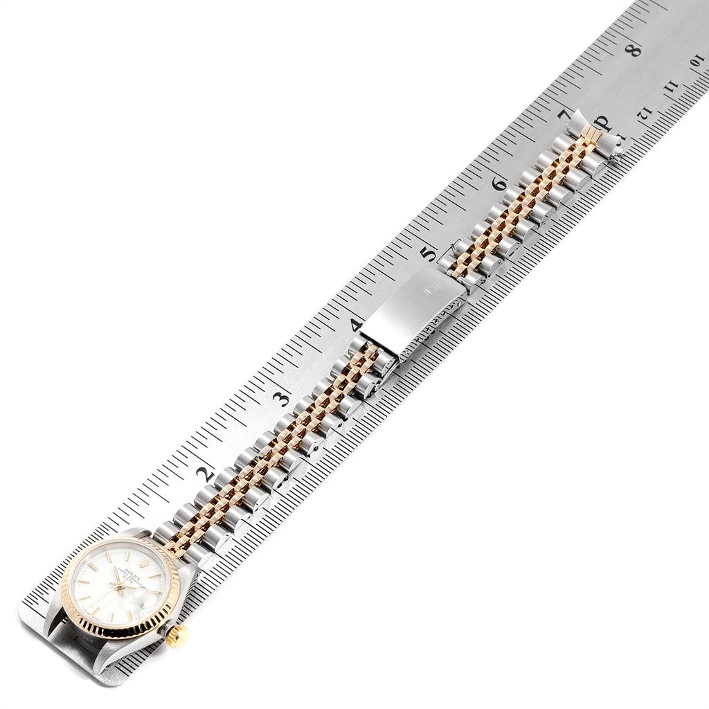 The image shows a Rolex Datejust 69173 Women's Stainless Steel White Dial 69173 Women's Stainless Steel White Dial watch placed diagonally on a ruler, highlighting its bracelet and clasp.
