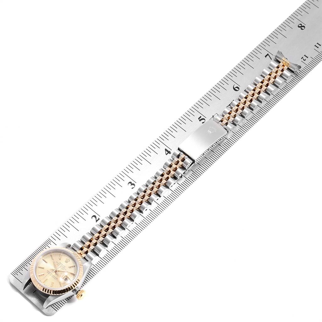 This image shows a Rolex Datejust 69173 Women's Stainless Steel Champagne Dial 69173 Women's Stainless Steel Champagne Dial watch lying flat on a ruler, highlighting the bracelet and part of the face.