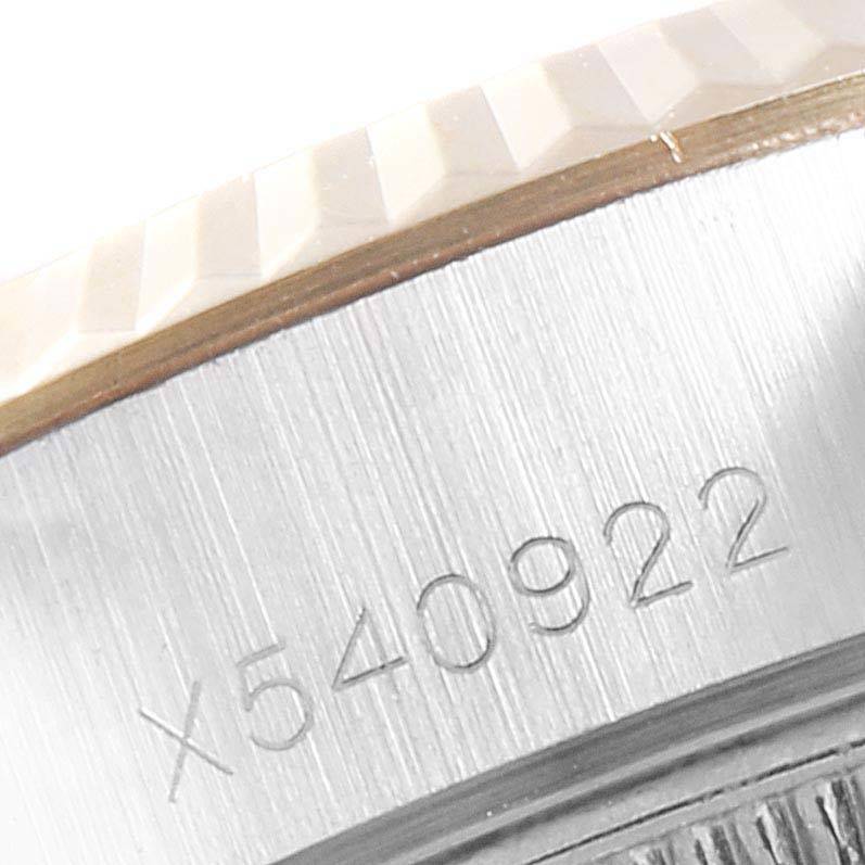 The image shows a close-up of the engraved serial number and fluted bezel of a Rolex Datejust 69173 Women's Stainless Steel Champagne Dial 69173 Women's Stainless Steel Champagne Dial watch.