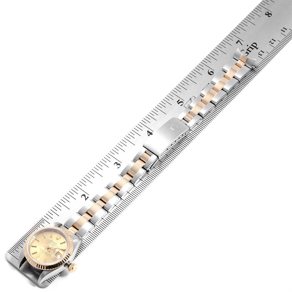 The Rolex Datejust 69173 Women's Steel and Gold (two tone) Champagne Dial 69173 Women's Steel and Gold (two tone) Champagne Dial watch is shown with its face, crown, and bracelet, measured against a metal ruler.