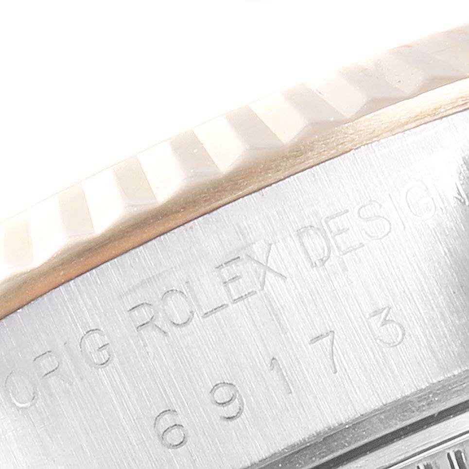 The image shows a close-up of the side of the bezel and case with engraved text of a Rolex Datejust 69173 Women's Steel and Gold (two tone) Champagne Dial 69173 Women's Steel and Gold (two tone) Champagne Dial watch.