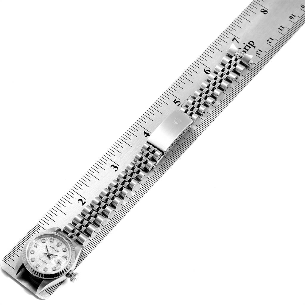 The image shows a Rolex Datejust 79174 Women
s Stainless Steel Silver Dial 79174 Women
s Stainless Steel Silver Dial watch laid flat alongside a ruler, presenting the face, bracelet, and clasp.