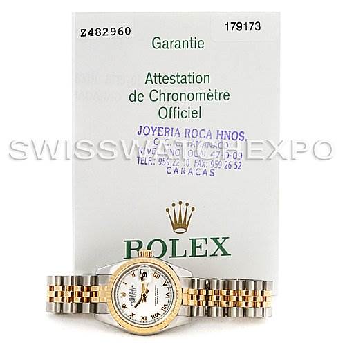 The image shows the front view of a Rolex Datejust 179173 Women's Steel and Gold (two tone) White Dial 179173 Women's Steel and Gold (two tone) White Dial watch and its warranty card in the background.