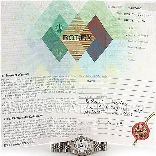 The image shows a Rolex Datejust 79174 Women's Stainless Steel White Dial 79174 Women's Stainless Steel White Dial watch placed in front of its warranty paperwork and certificate.