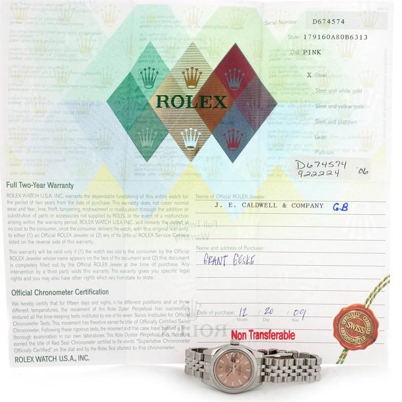 The image shows a Rolex Datejust 179160 Women's Stainless Steel Pink Dial 179160 Women's Stainless Steel Pink Dial watch placed in front of its official warranty and certification paperwork.