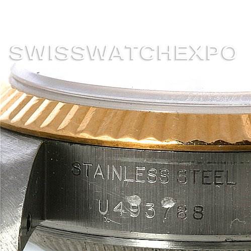 The image shows an angled close-up of the Rolex Datejust 69173 Women's Stainless Steel Beige Dial 69173 Women's Stainless Steel Beige Dial watch, highlighting the fluted bezel and engraved serial number on the case.