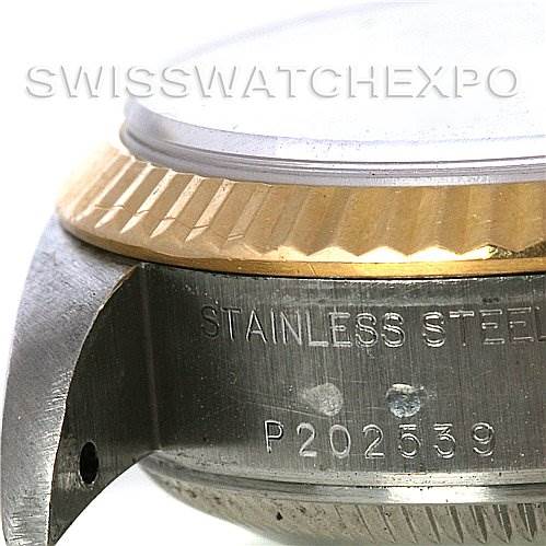 This close-up of the Rolex Datejust 79173 Women's Stainless Steel Black Dial 79173 Women's Stainless Steel Black Dial watch shows the side of the stainless steel case, the serial number, and part of the gold fluted bezel.
