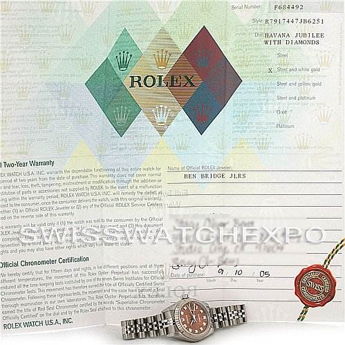 The image shows a Rolex Datejust 79174 Women's Stainless Steel Brown Dial 79174 Women's Stainless Steel Brown Dial watch along with its warranty card and chronometer certification, all viewed from above.