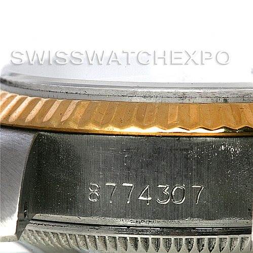 This image shows a close-up of the side of a Rolex Datejust 69173 Women's Stainless Steel White Dial 69173 Women's Stainless Steel White Dial watch, highlighting the serial number and the gold fluted bezel.