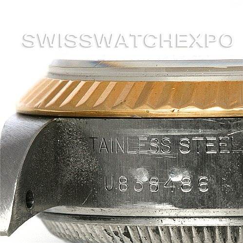 A side view of the Rolex Datejust 69173 Women's Stainless Steel Black Dial 69173 Women's Stainless Steel Black Dial watch, showing the stainless steel case with its serial number and the gold fluted bezel.