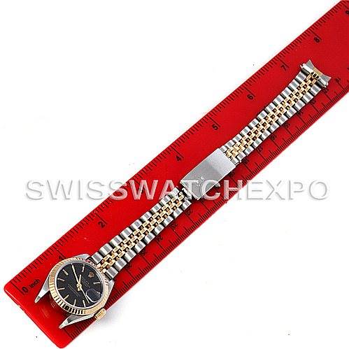 The image shows a top-down view of a Rolex Datejust 69173 Women's Stainless Steel Black Dial 69173 Women's Stainless Steel Black Dial watch with a jubilee bracelet placed next to a red ruler for size reference.