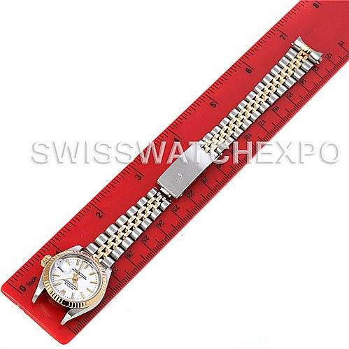 The Rolex Datejust 69173 Women's Stainless Steel White Dial 69173 Women's Stainless Steel White Dial watch is shown from a top-down angle, focusing on the dial, bracelet, and clasp, positioned next to a red ruler.