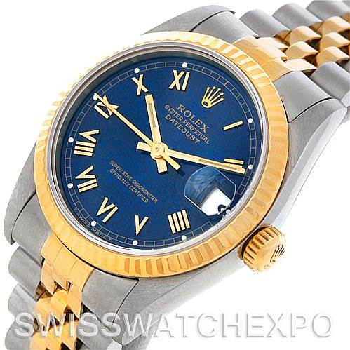 This image shows a Rolex Mid-Size 68273 Women's Stainless Steel Blue Dial 68273 Women's Stainless Steel Blue Dial Datejust watch at an angle highlighting the blue dial, gold bezel, and two-tone bracelet.