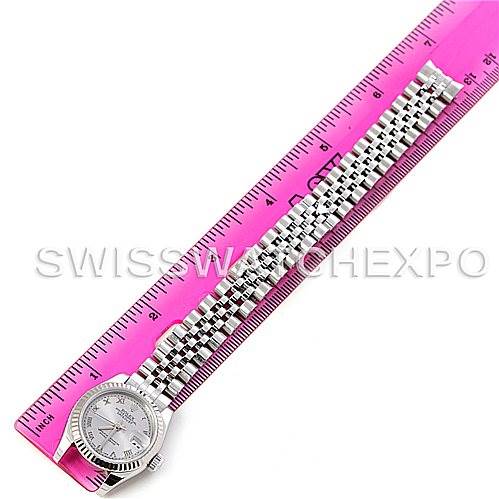 The Rolex Datejust 179174 Women's Stainless Steel Silver Dial 179174 Women's Stainless Steel Silver Dial watch is shown from a top-down angle, highlighting the face and metal bracelet next to a ruler for scale.