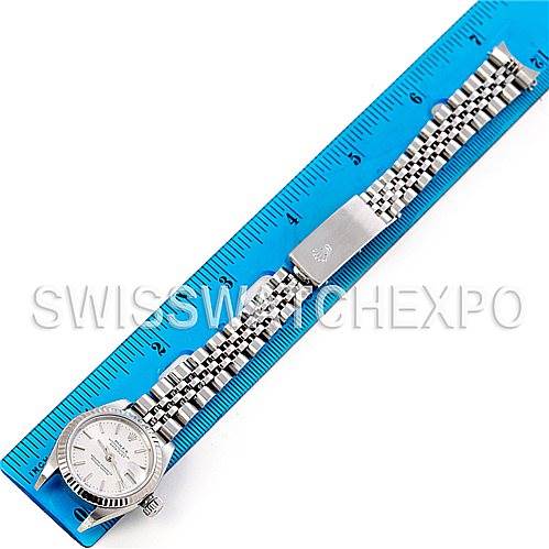 The image shows an overhead view of a Rolex Datejust 79174 Women's Stainless Steel Silver Dial 79174 Women's Stainless Steel Silver Dial watch laid out next to a blue ruler for scale.